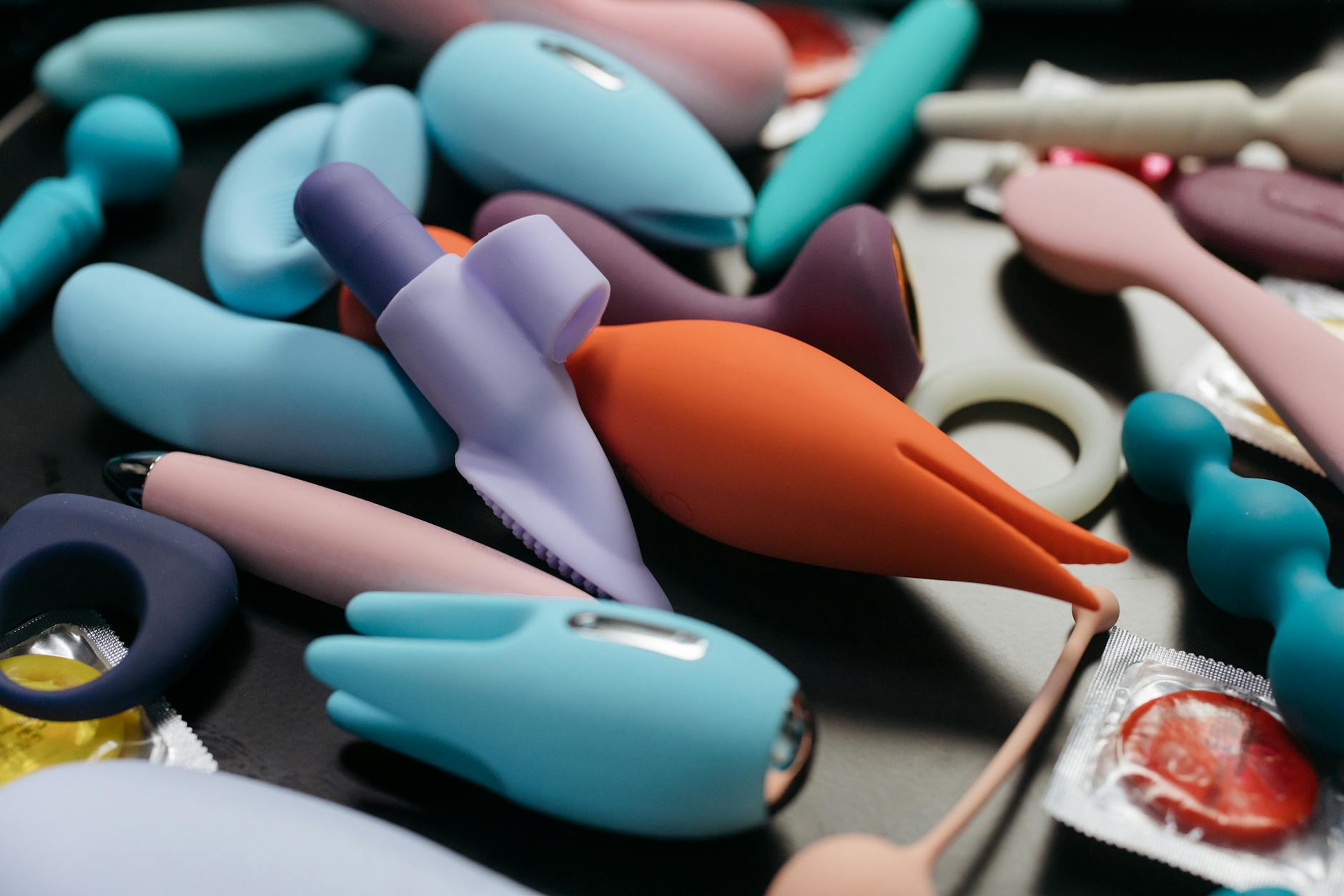 Kolorowe wibratory dla dorosłych, w tym Lemon Vibrator, ułożone na czarnym tle